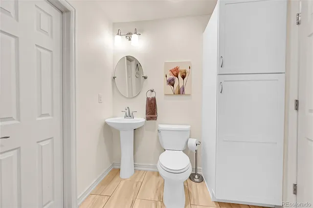 a bathroom with a toilet a sink and mirror