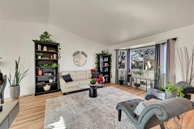 a living room with furniture a bookshelf and a large window