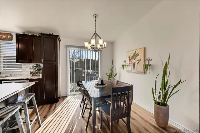 a dining room with furniture potted plants and wooden floor