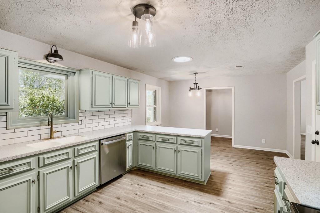 2021 Irwin Bridge Road Northwest Conyers, GA 30012 - Photo 13 of 43 a kitchen with a sink cabinets and wooden floor