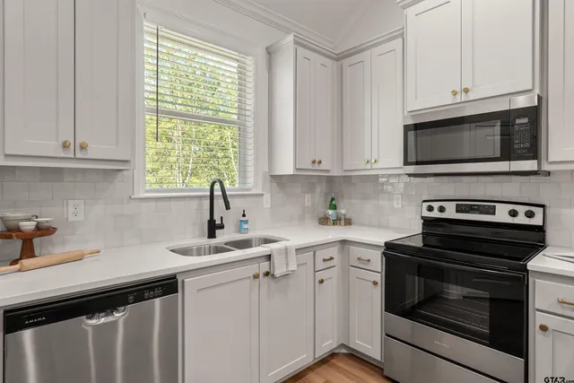 a kitchen with cabinets appliances a sink and a window