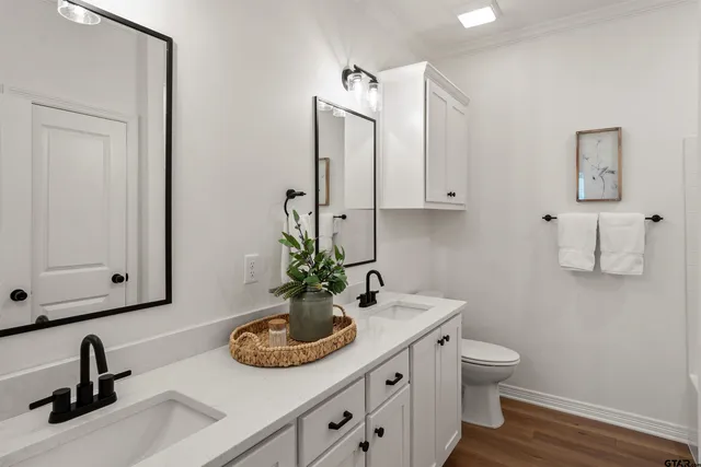 a bathroom with double vanity sinks a vanity and a mirror