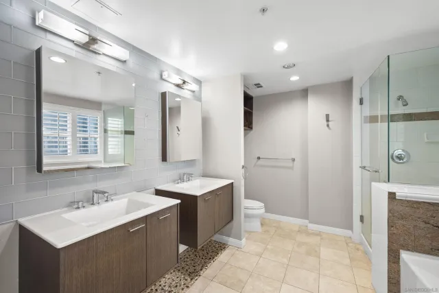 a view of a big room with windows and chandelier fan