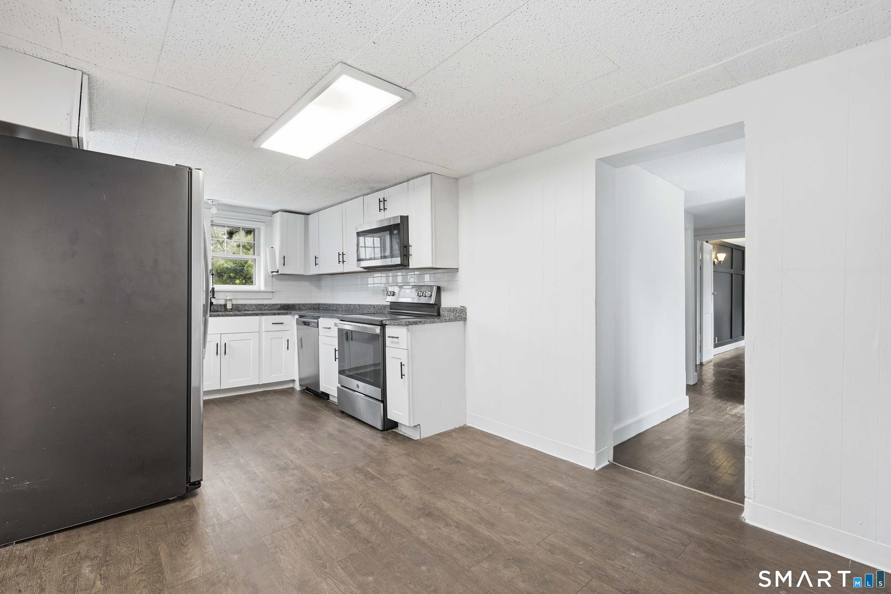 660 Opening Hill Road Madison, CT 06443 - Photo 23 of 36 a kitchen with white cabinets and stainless steel appliances