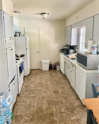 a large white kitchen with white cabinets and stainless steel appliances
