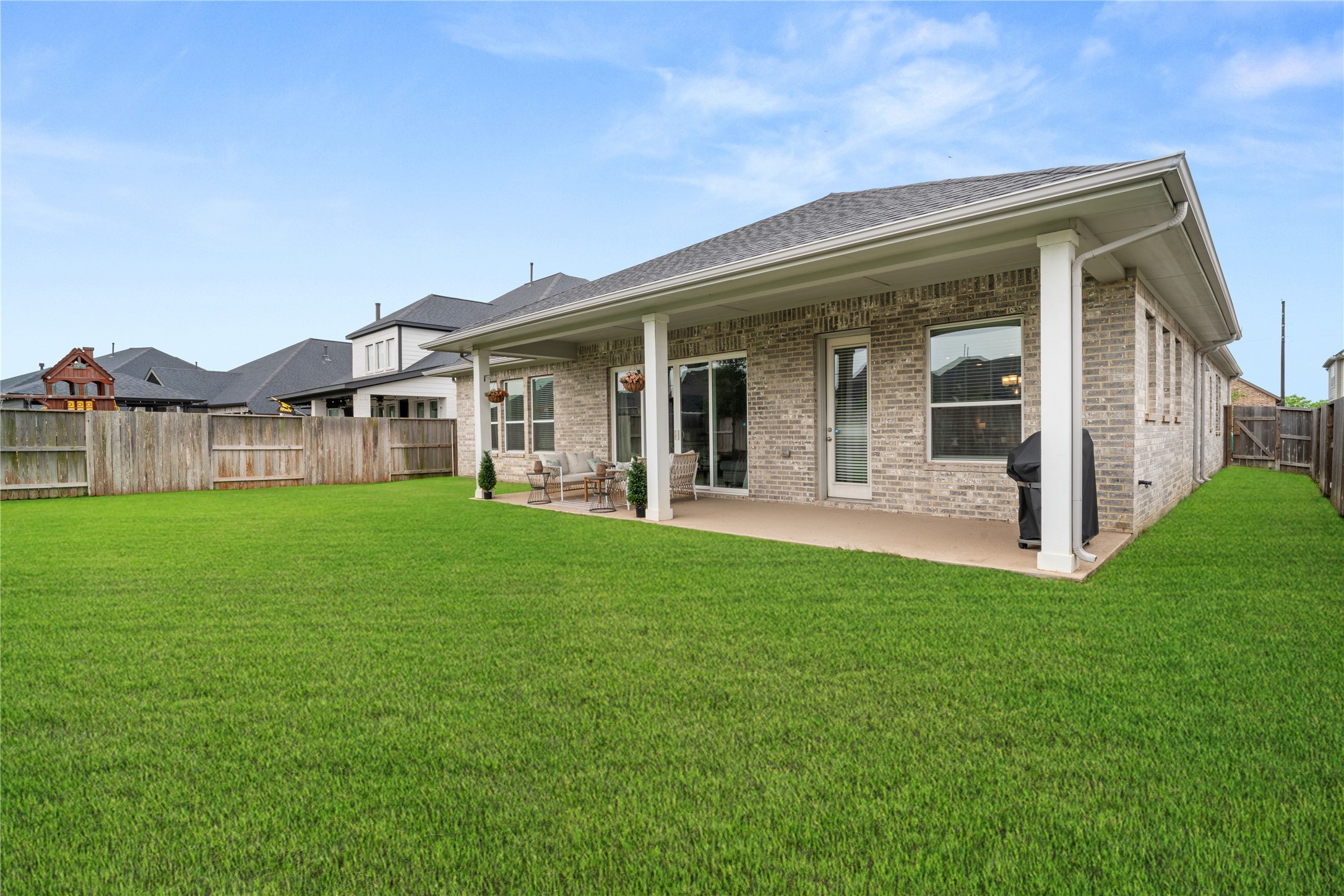 3118 Swift Way Katy, TX 77493 - Photo 34 of 34 Covered Patio & Backyard – Covered patio area perfect for outdoor seating and dining, overlooking a fully fenced backyard with plenty of green space.