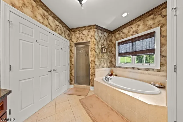 a spacious bathroom with a tub a double vanity sink and window