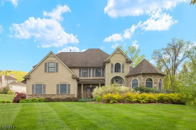 a front view of a house with a garden and trees