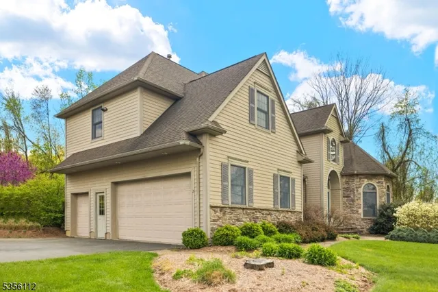 a view of a white house next to a yard with potted plants