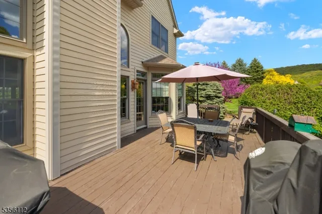 a patio with wooden floor a yard a table and chairs