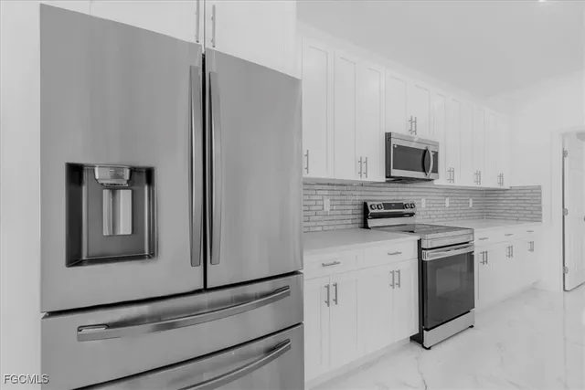 a kitchen with cabinets stainless steel appliances and sink
