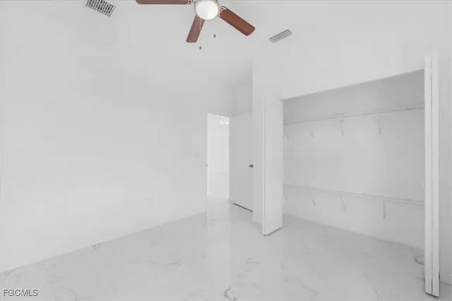 a view of kitchen with refrigerator stove and white cabinets