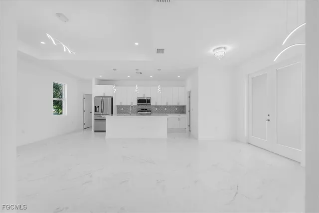 a kitchen with stainless steel appliances refrigerator a microwave and white cabinets