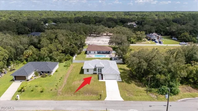 an aerial view of residential houses with outdoor space and trees