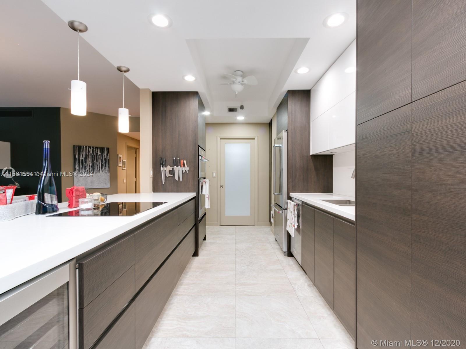 a large kitchen with a large counter top cabinets and stainless steel appliances