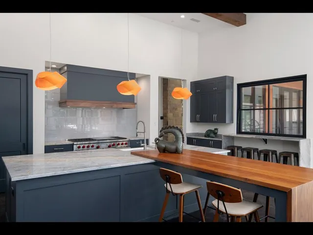 a living room with granite countertop furniture a flat screen tv and a large window