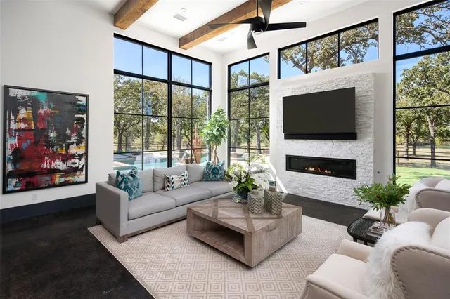 a living room with furniture a large window and a flat screen tv