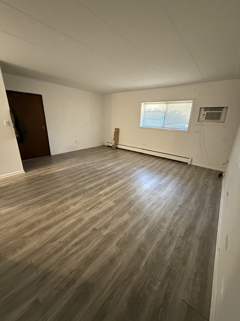 138 East Bailey Road, Unit B Naperville, IL 60565 - Photo 3 of 20 an empty room with wooden floor and windows