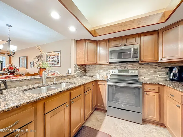 a kitchen with stainless steel appliances granite countertop a stove sink and cabinets