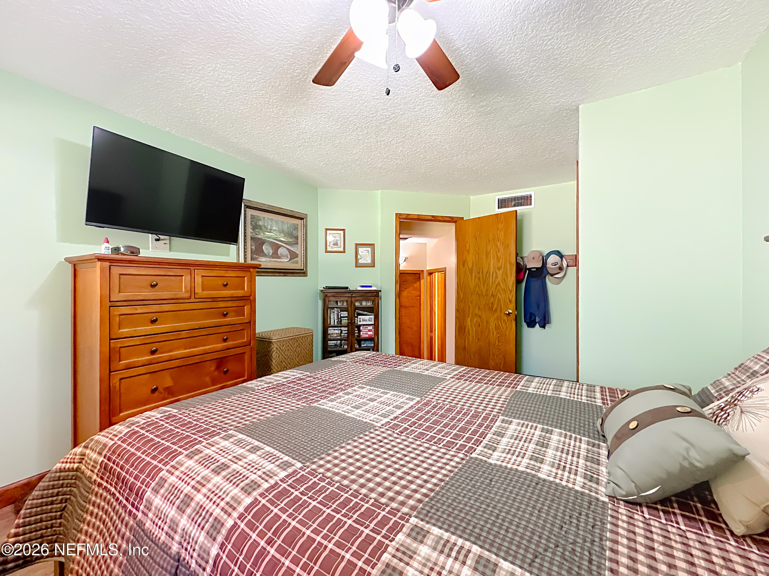 2910 Ravines Road, Unit 1103 Middleburg, FL 32068 - Photo 24 of 36 a bedroom with a bed and a flat screen tv