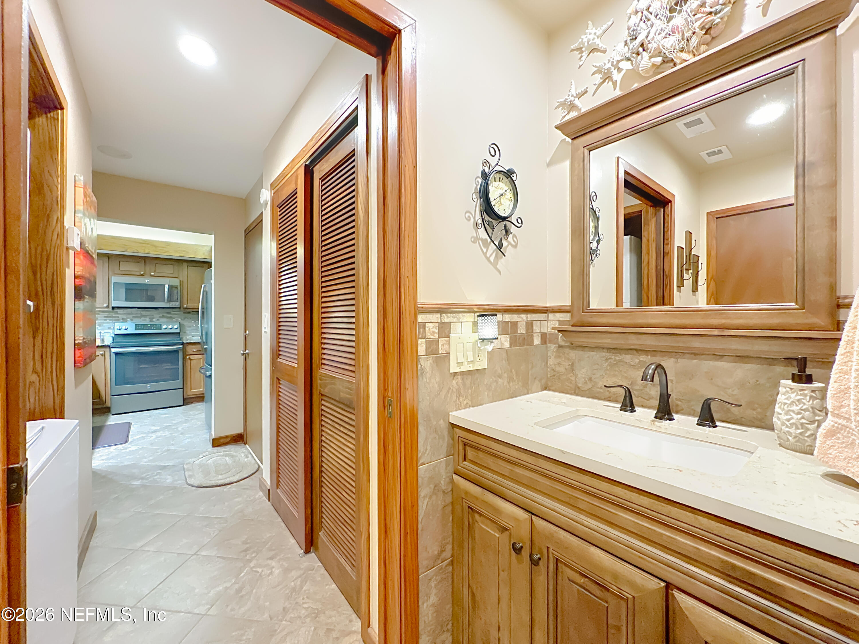 2910 Ravines Road, Unit 1103 Middleburg, FL 32068 - Photo 28 of 36 a bathroom with a sink a mirror and a shower
