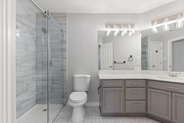 a bathroom with a double vanity sink mirror and toilet