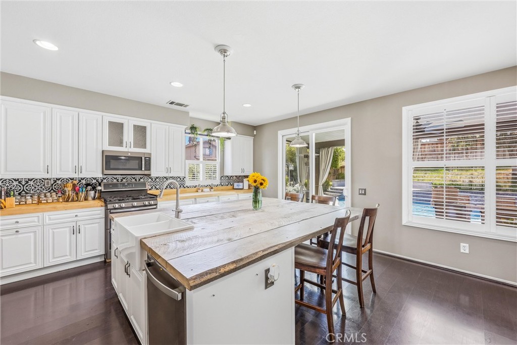 8402 Lindenhurst Street Riverside, CA 92508 - Photo 15 of 60 a kitchen with a stove a sink and a refrigerator