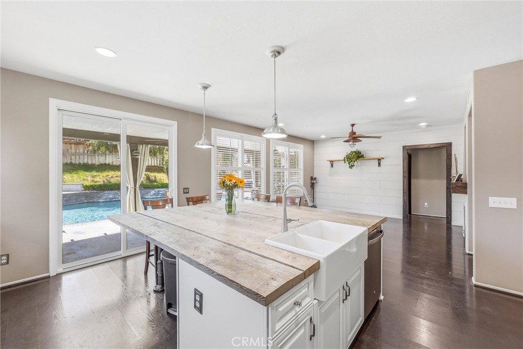 8402 Lindenhurst Street Riverside, CA 92508 - Photo 19 of 60 a kitchen with stainless steel appliances granite countertop a sink a refrigerator and a wooden floor