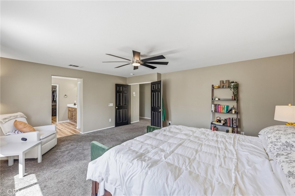 8402 Lindenhurst Street Riverside, CA 92508 - Photo 24 of 60 a bedroom with a large bed and a chandelier