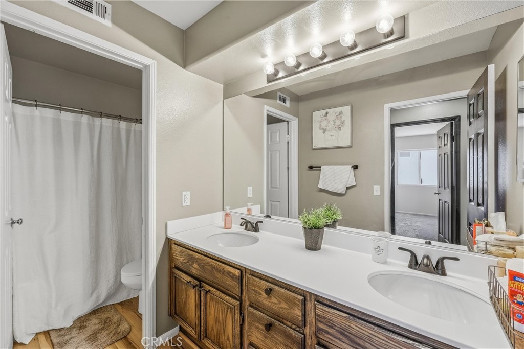 8402 Lindenhurst Street Riverside, CA 92508 - Photo 30 of 60 a bathroom with a double vanity sink and a mirror