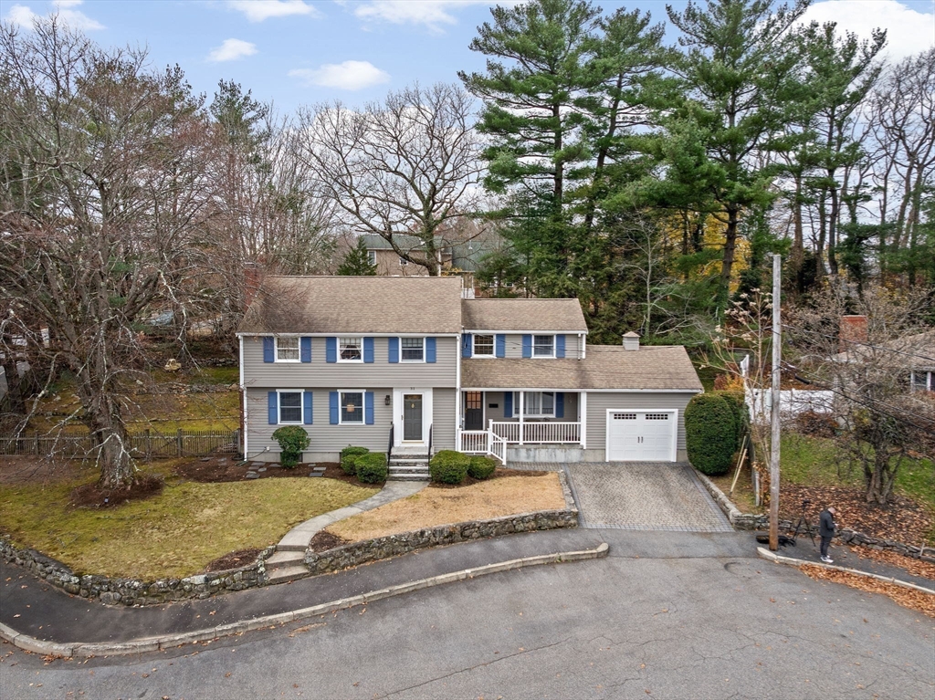 a front view of a house with a yard and large trees