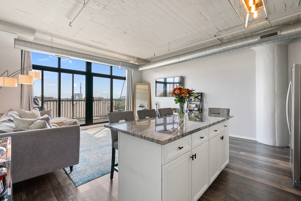 1525 South Sangamon Street, Unit 514 Chicago, IL 60608 - Photo 8 of 16 a dining hall with stainless steel appliances granite countertop a sink dishwasher and a refrigerator with wooden floor