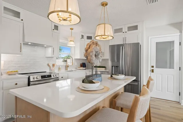 a kitchen with a appliances and chandelier