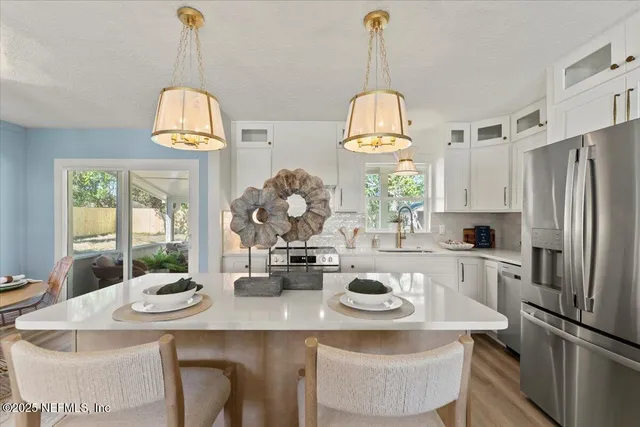 a kitchen with stainless steel appliances granite countertop a stove a refrigerator and a wooden floor