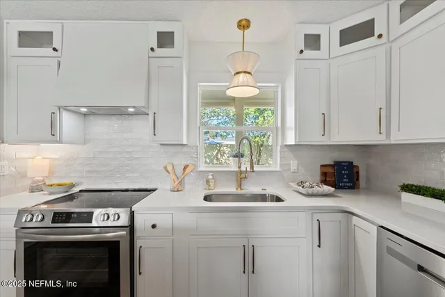 a kitchen with stainless steel appliances granite countertop a sink a window and cabinets