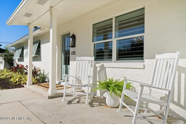 a living room with furniture a chandelier and a flat screen tv