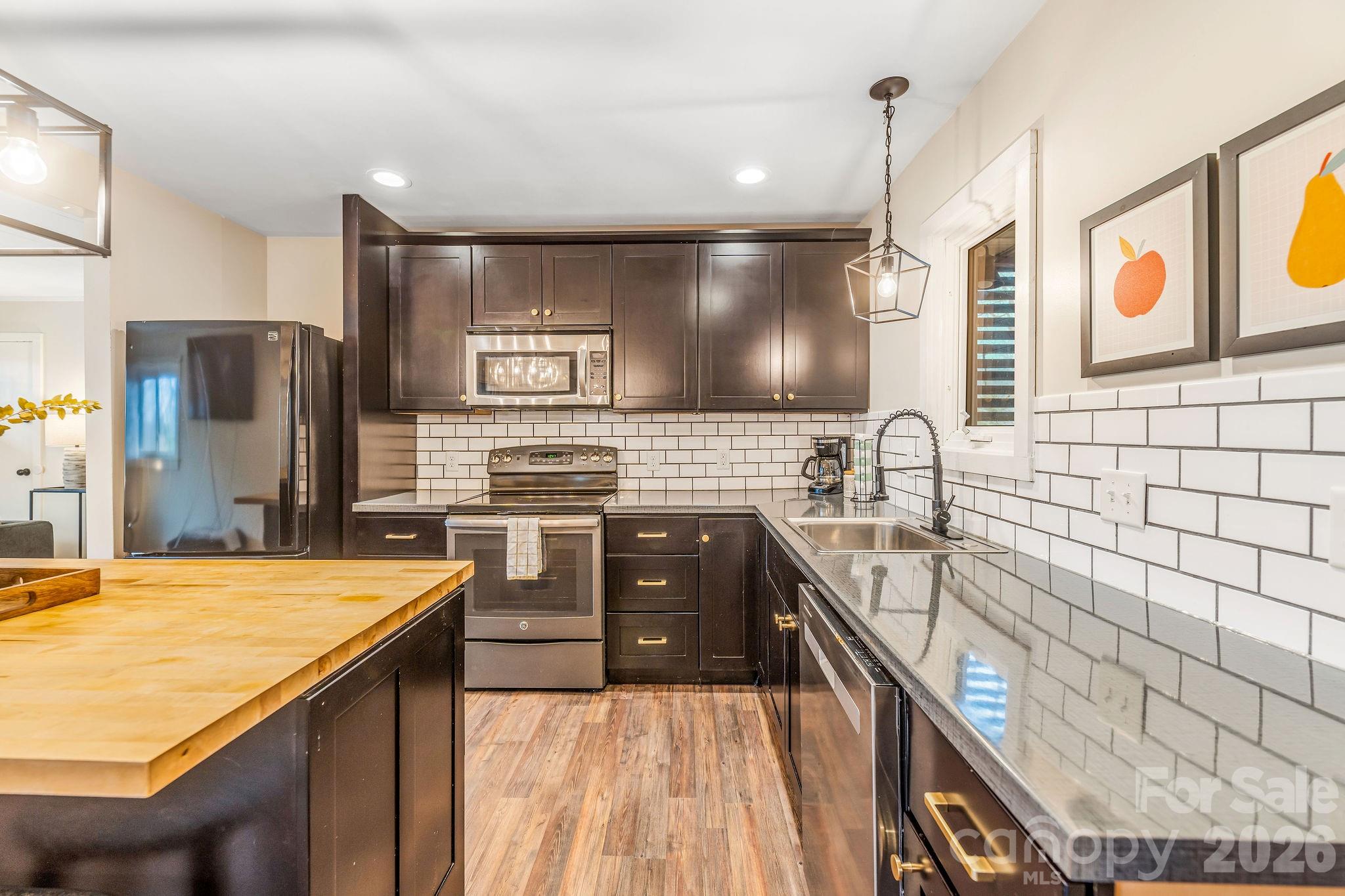 96 Oak Hill Road Candler, NC 28715 - Photo 11 of 41 a kitchen with stainless steel appliances kitchen island granite countertop a sink stove and refrigerator
