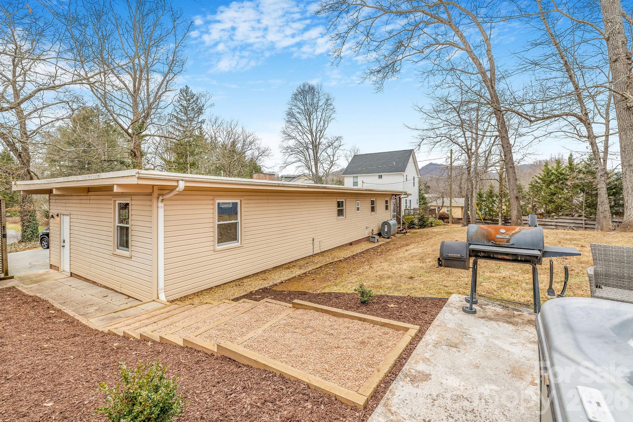 96 Oak Hill Road Candler, NC 28715 - Photo 36 of 41 a view of a backyard with a barn and a large tree