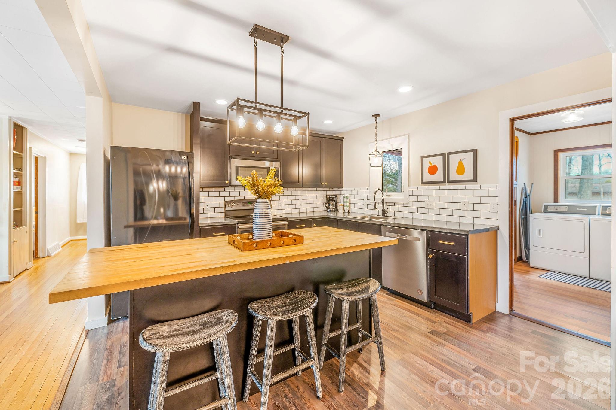 96 Oak Hill Road Candler, NC 28715 - Photo 10 of 41 a kitchen with stainless steel appliances granite countertop a kitchen island a stove a table and chairs