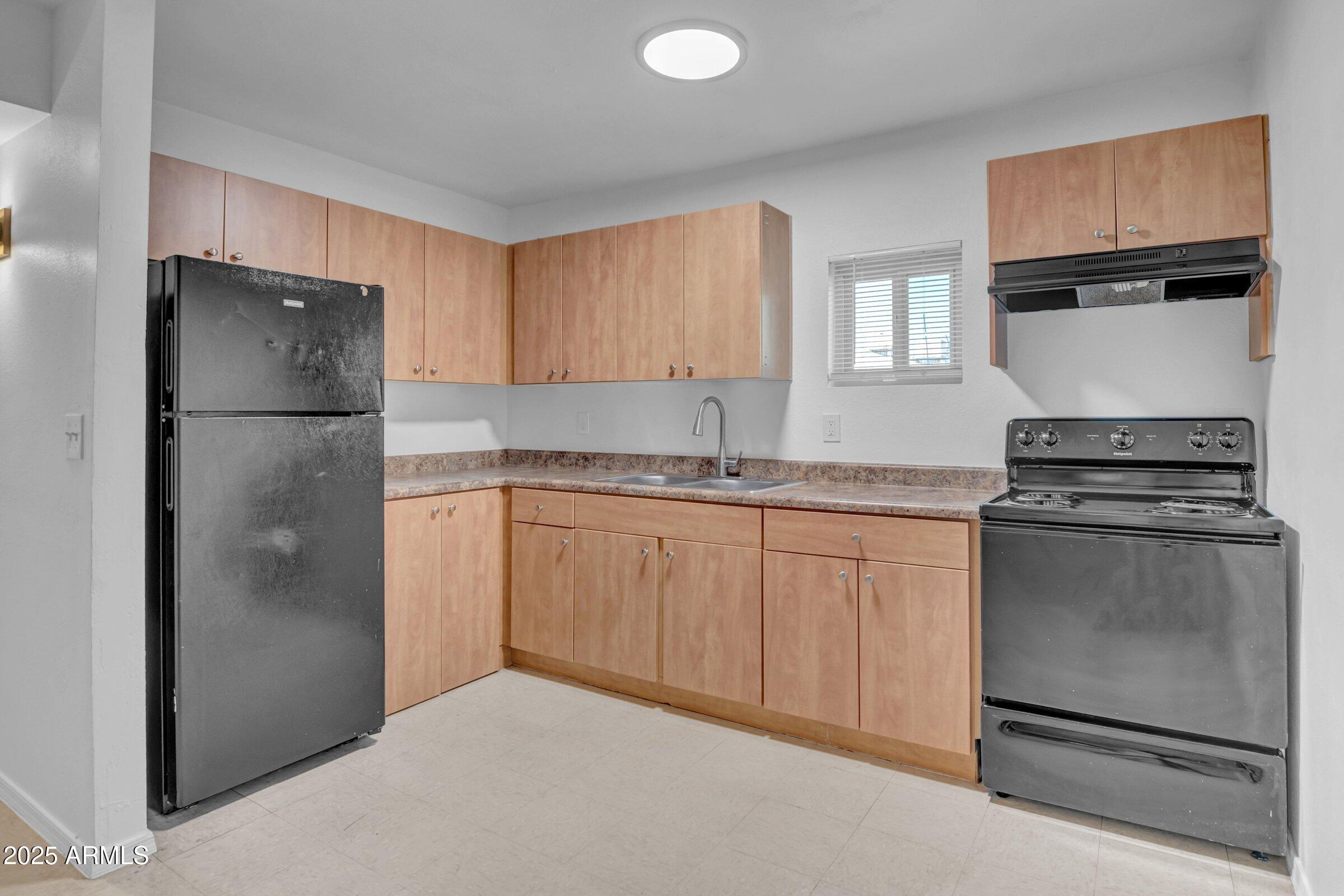 2234 West Hazelwood Street Phoenix, AZ 85015 - Photo 11 of 22 a kitchen with a refrigerator sink and cabinets