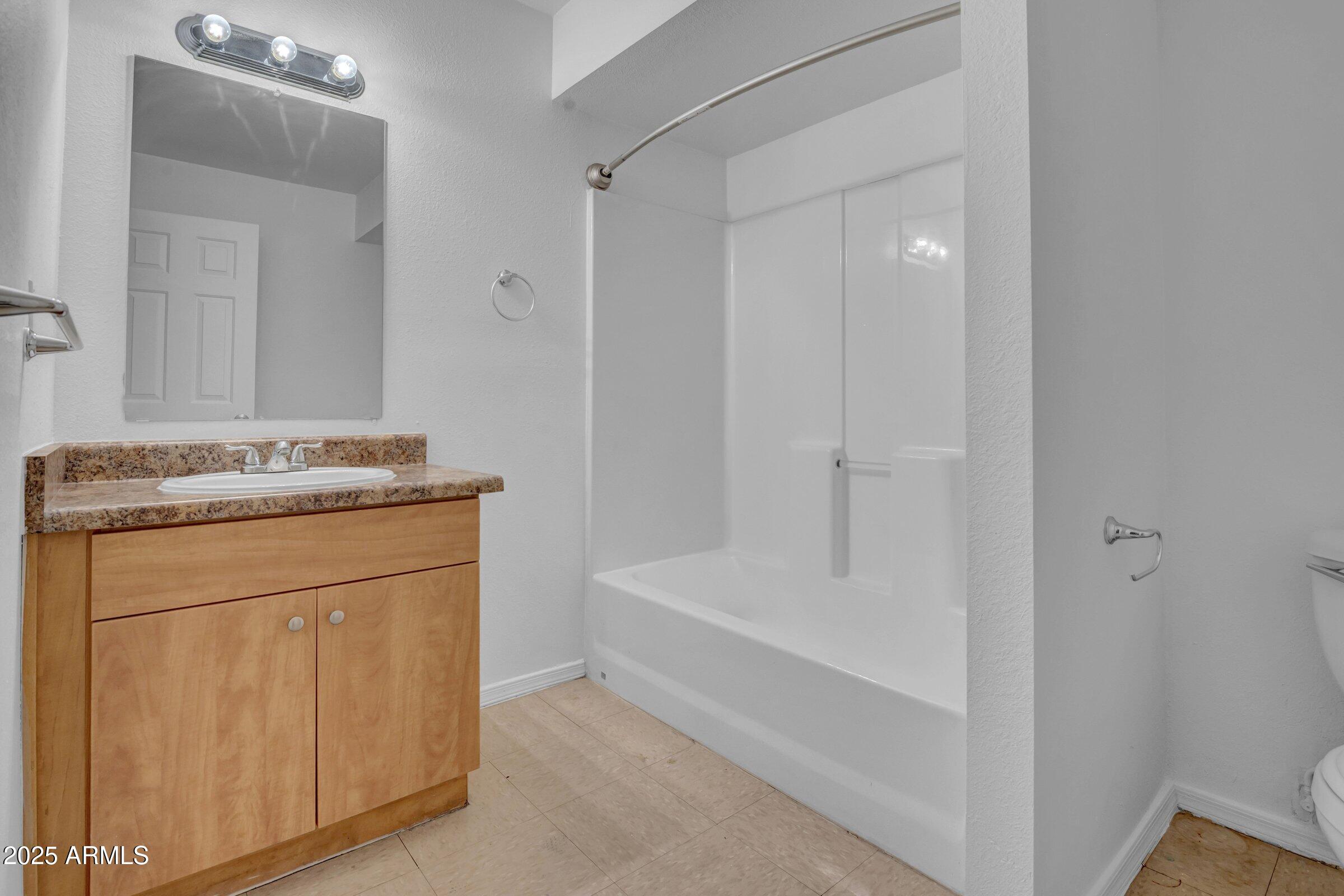 2234 West Hazelwood Street Phoenix, AZ 85015 - Photo 13 of 22 a bathroom with a granite countertop sink a toilet and shower