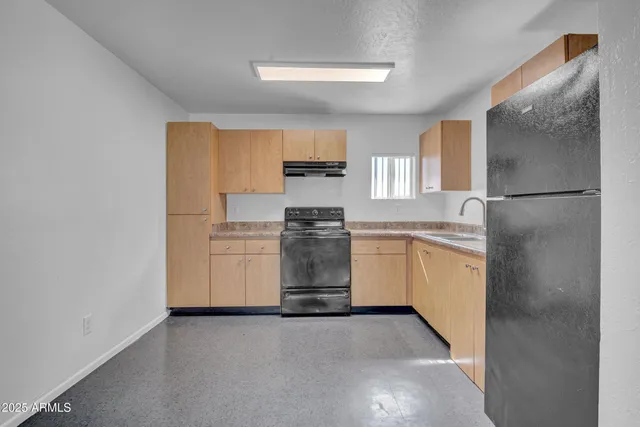 a kitchen with a refrigerator sink and cabinets