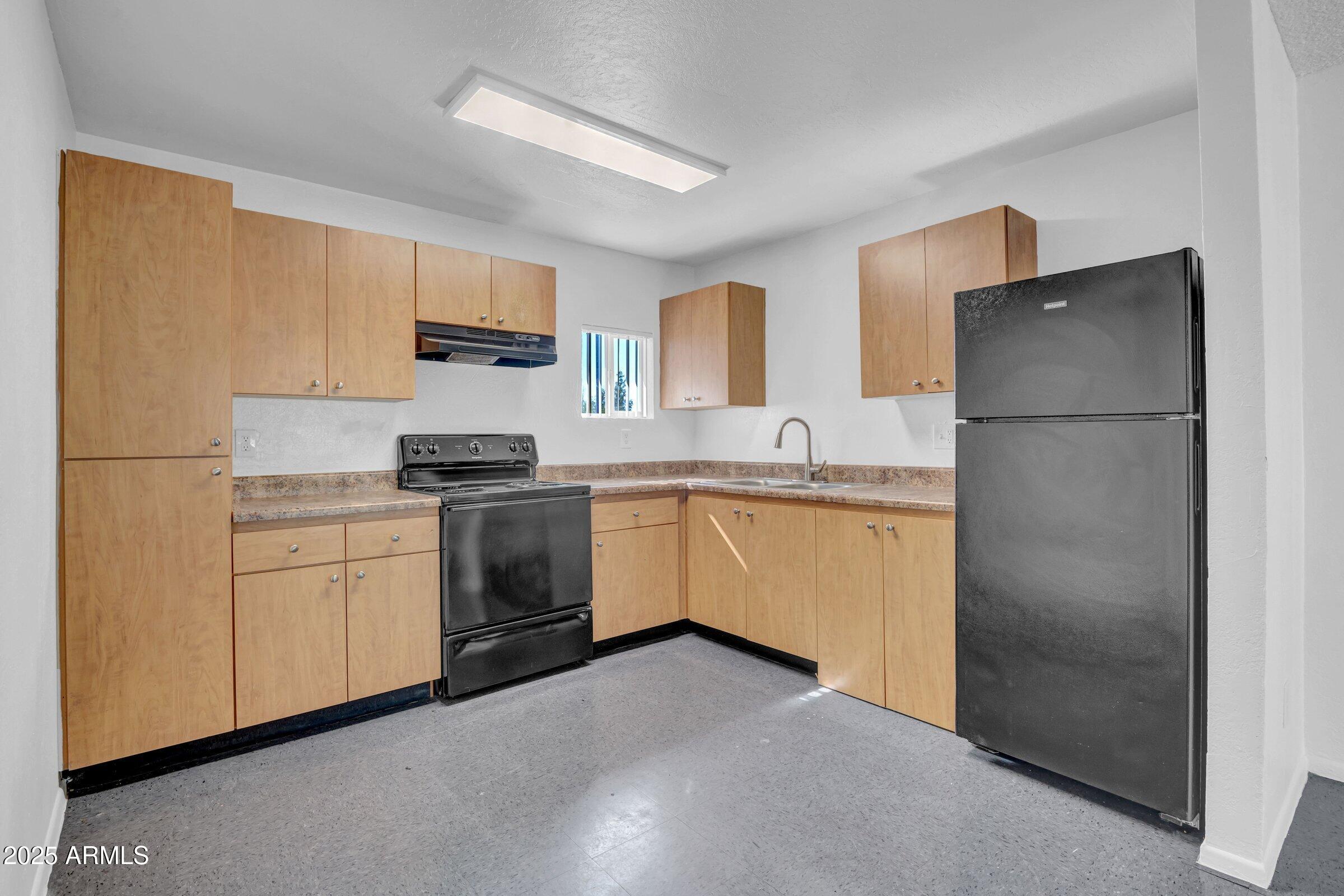 2234 West Hazelwood Street Phoenix, AZ 85015 - Photo 17 of 22 a kitchen with a refrigerator sink and cabinets