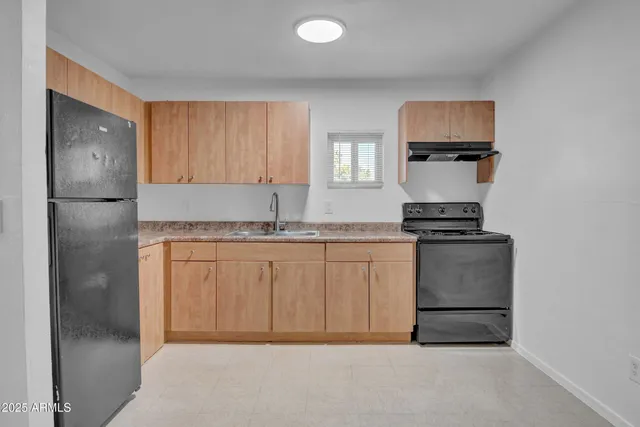 a kitchen with a refrigerator sink and cabinets