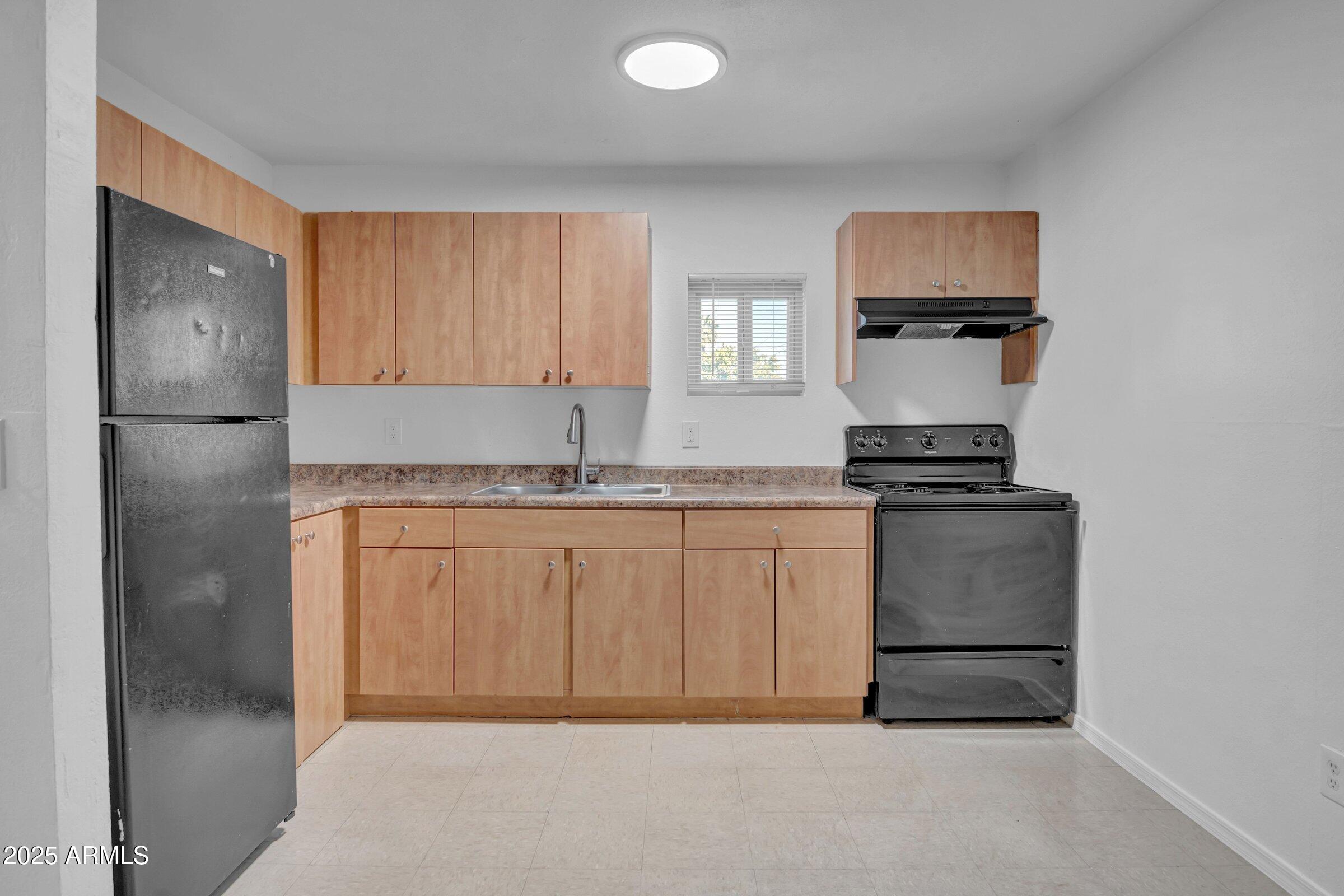 2234 West Hazelwood Street Phoenix, AZ 85015 - Photo 10 of 22 a kitchen with white cabinets and appliances