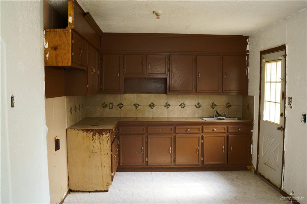 5909 Kountry Loop Mission, TX 78574 - Photo 9 of 23 a kitchen with granite countertop cabinets and white appliances