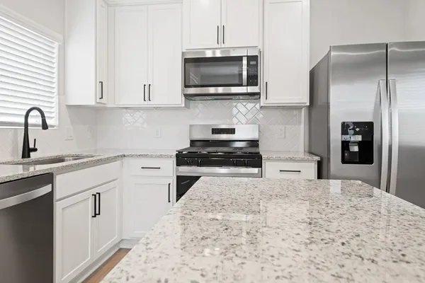 a kitchen with a sink stove and microwave