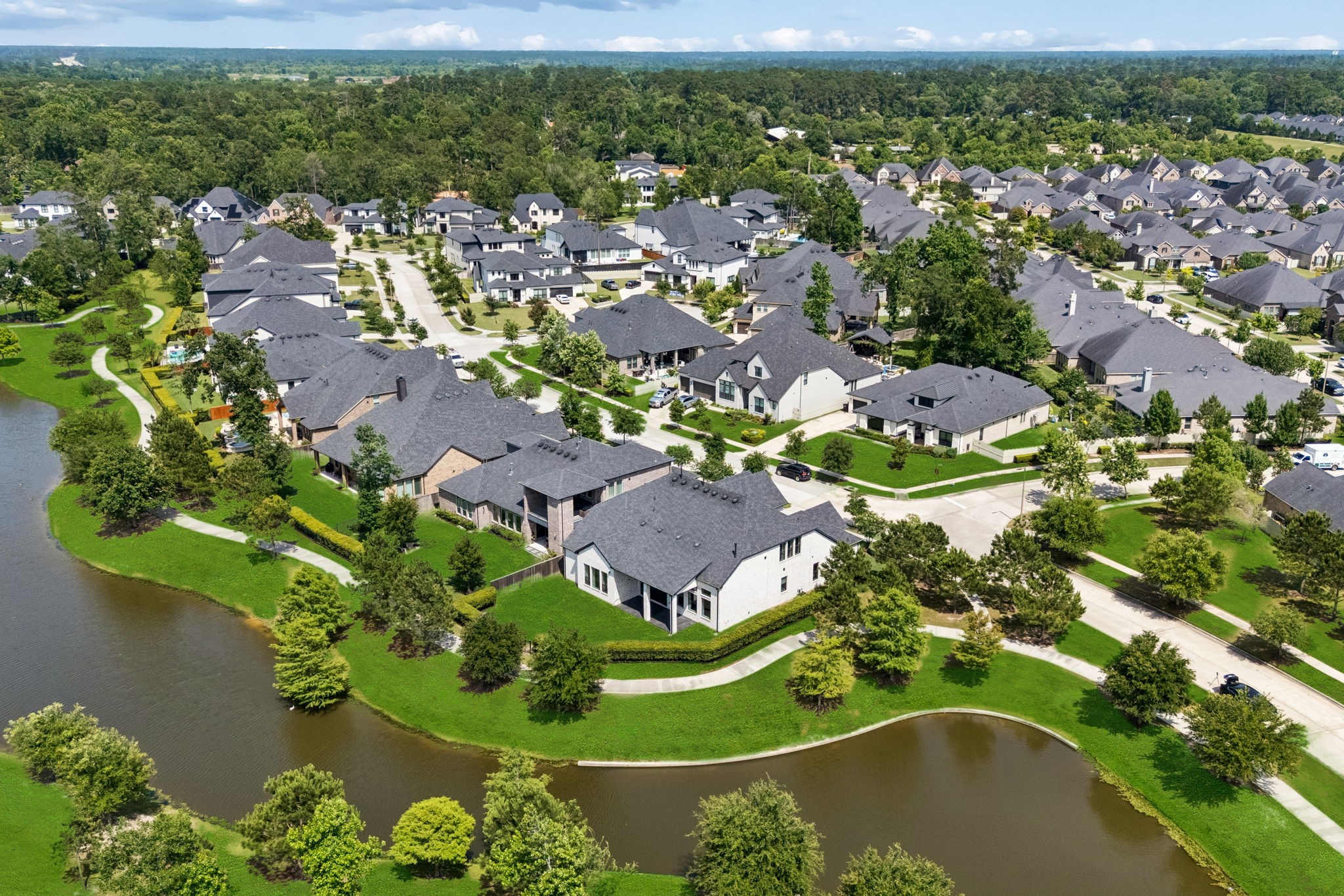 10102 South Goshawk Trail Conroe, TX 77385 - Photo 42 of 46 an aerial view of a house with a garden and lake view