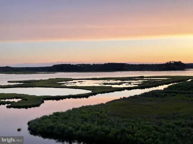 a bedroom with a bed and window with dresser