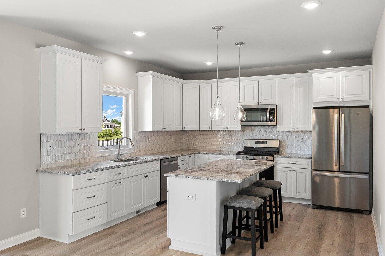 3090 West 105th Avenue Crown Point, IN 46307 - Photo 11 of 22 a kitchen with white cabinets stainless steel appliances and wooden floors